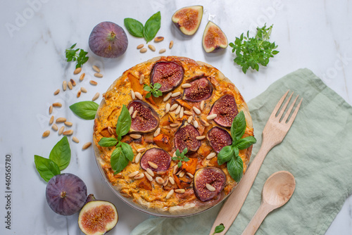 Home made autumn quiche with pumpkin and figs on a table