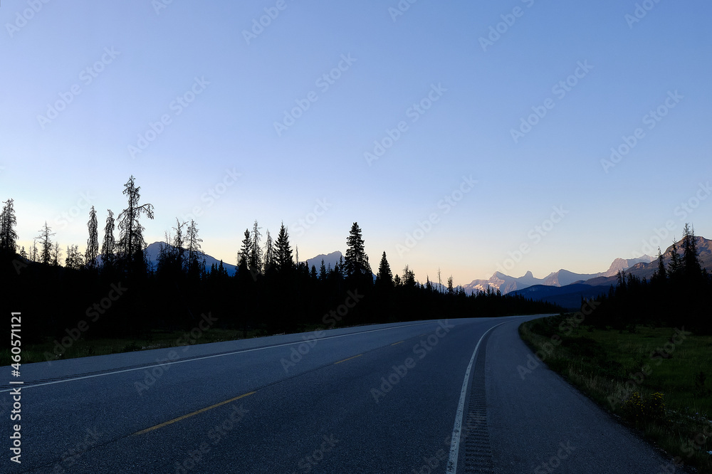 sunrise in the mountains, driving a mountain road in the Rockies, the sun rising over the mountains