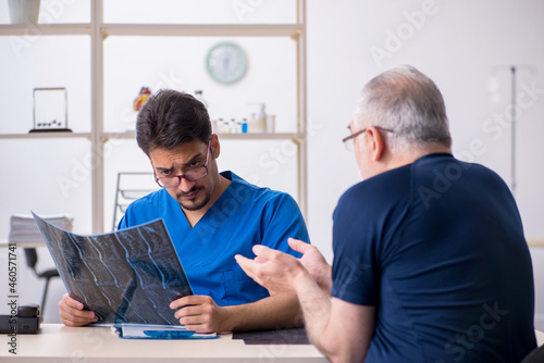 Old man visiting young male doctor radiologist