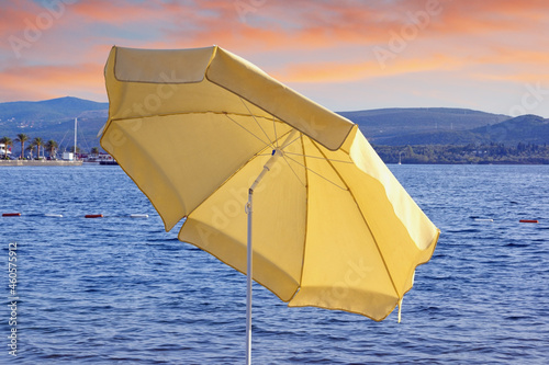 Yellow beach umbrella on coast of bay at sunset. Montenegro