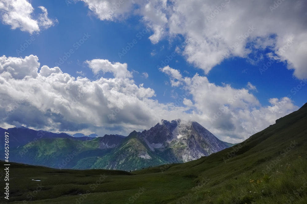 high rocky mountains with amazing clouds on the blue sky in austria