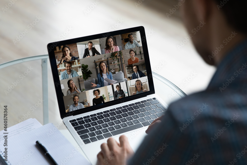 View over businessman shoulder group video call on laptop screen, diverse colleagues business partners chatting online, engaged in internet conference, meeting by webcam, distance work concept - obrazy, fototapety, plakaty 