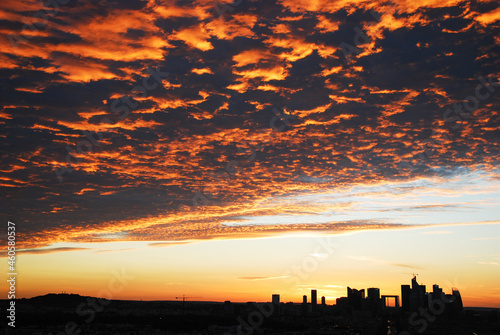 sunset skyline of La Defense district from arc de triomphe with with orange clouds. Paris. 