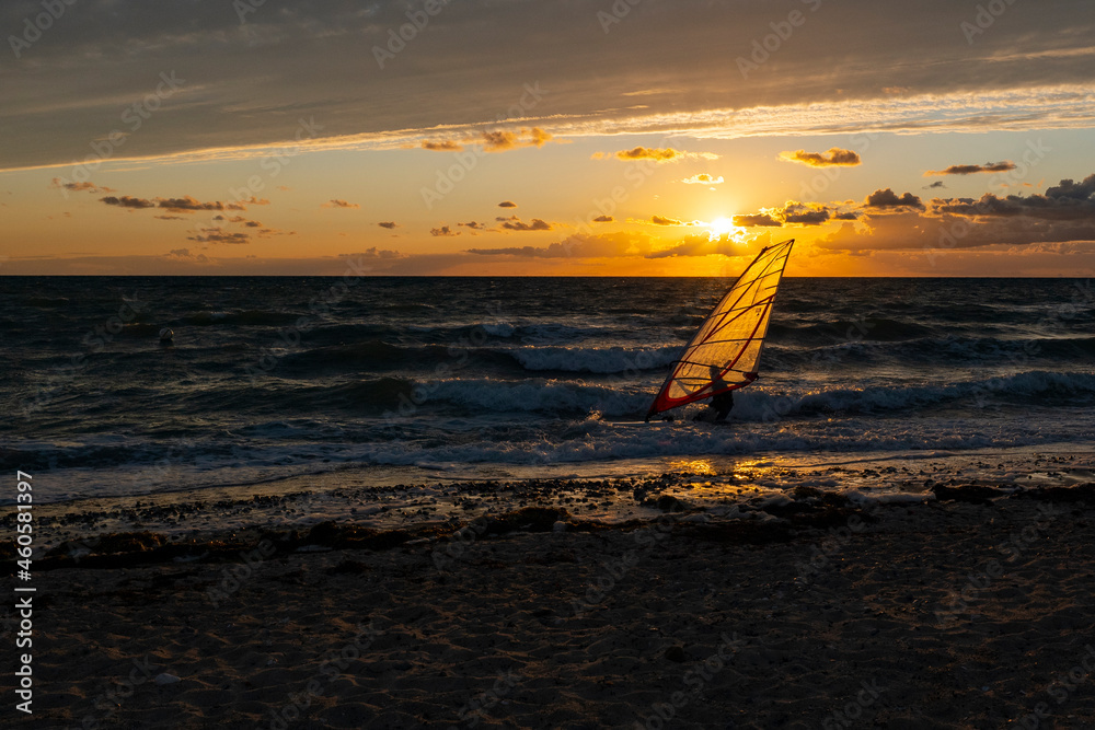 Sunset on the beach of the Baltic Sea with windsurfer
