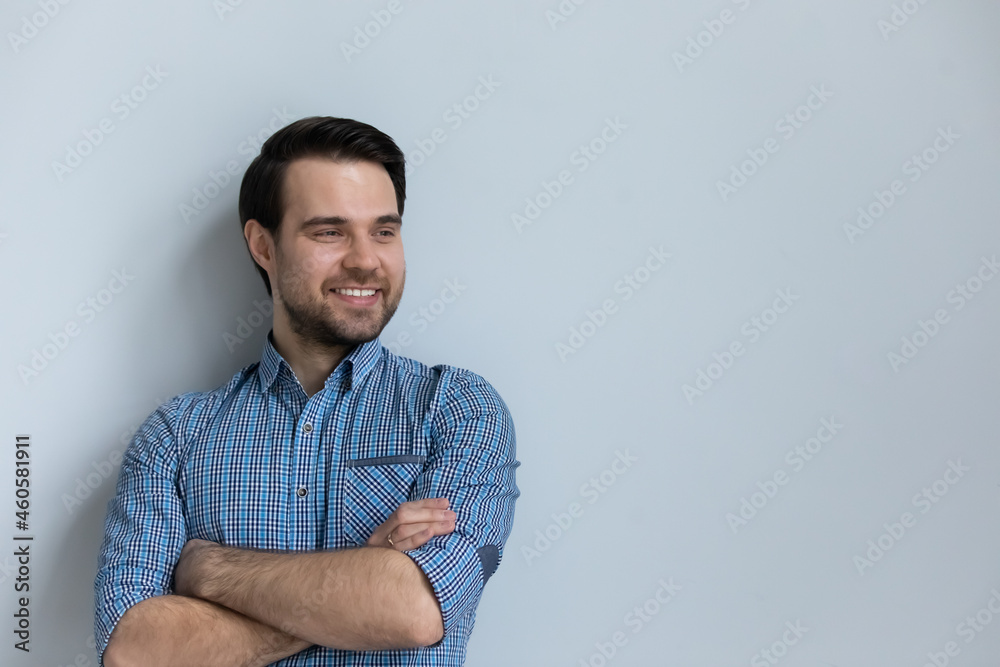 Smiling confident man with folded hands standing on grey studio background with copyspace isolated, looking in distance, successful businessman entrepreneur visualizing good future, new opportunity Smiling confident man with folded hands standing on grey studio background with copyspace isolated, looking in distance, successful businessman entrepreneur visualizing good future, new opportunity