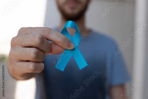 Blue november. Prostate Cancer Prevention Month. man holding blue ribbon. Men's health blue march, colorectal cancer prevention campaign