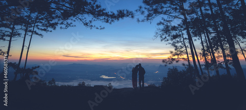 Silhouette couple with a beautifu mountain ridge and sky © Chumphol