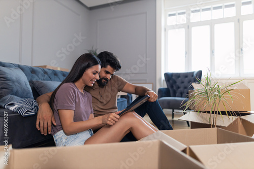 Young couple looking at their photo after relocating into a new home.