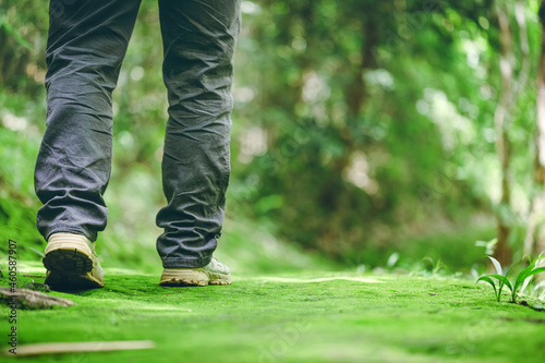 Hikers boots walking on moss in forest trail. Travel, Sports,Lifestyle Concept. © AungMyo