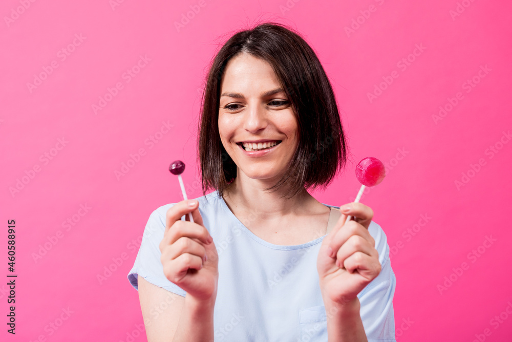 Young woman with sensitive teeth eating sweet lollipop on color background Young woman with sensitive teeth eating sweet lollipop on color background