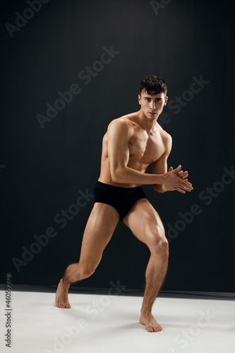 athletic men with a pumped-up muscular body black panties posing dark background