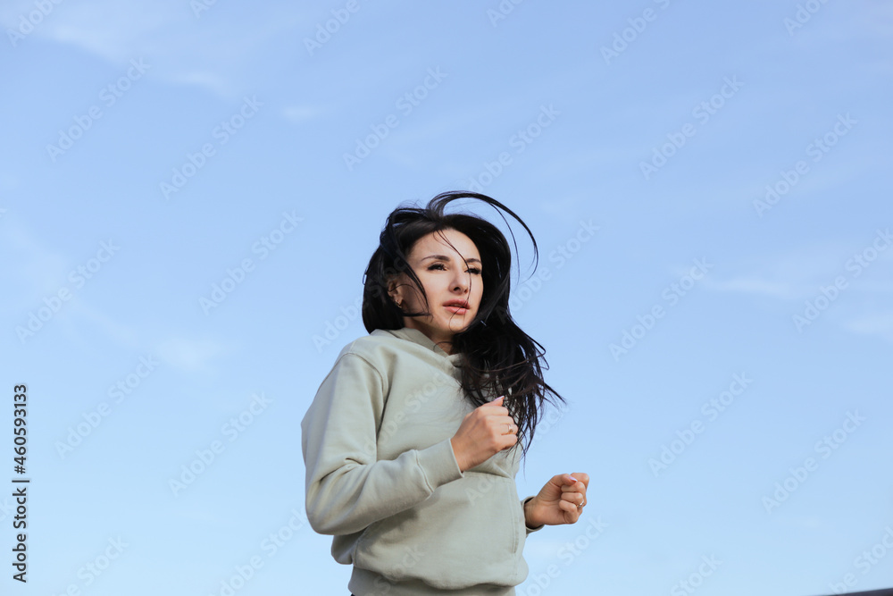 A woman in sweatshirts runs in the morning workout A woman in sweatshirts runs in the morning workout