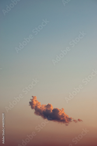 A single colorful cloud at sunrise sunset with lots of free space around it