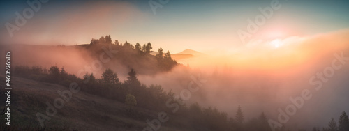 Panorama of valley covered with fog in a light