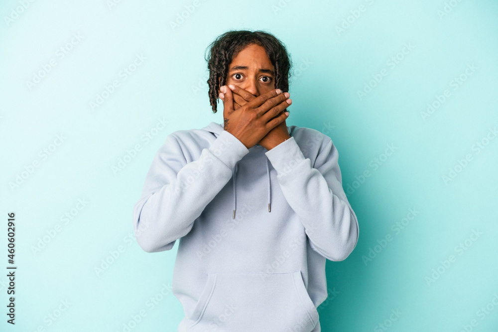 Young african american man isolated on blue background shocked covering mouth with hands. Young african american man isolated on blue background shocked covering mouth with hands.