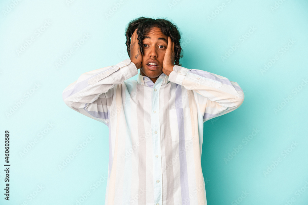 Young african american man isolated on blue background being shocked, she has remembered important meeting. Young african american man isolated on blue background being shocked, she has remembered important meeting.