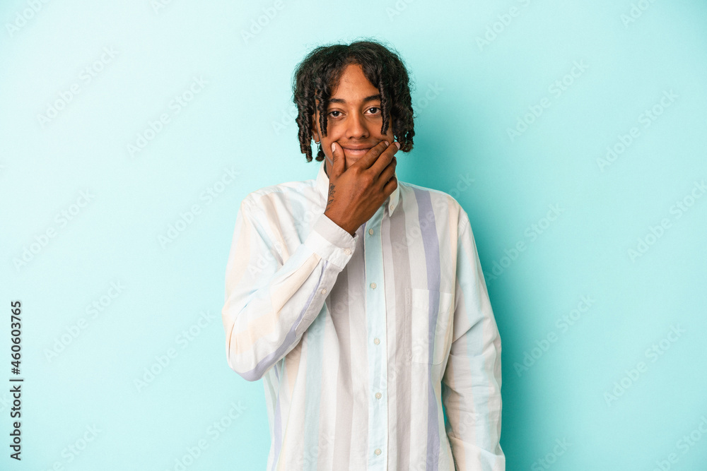 Young african american man isolated on blue background doubting between two options. Young african american man isolated on blue background doubting between two options.