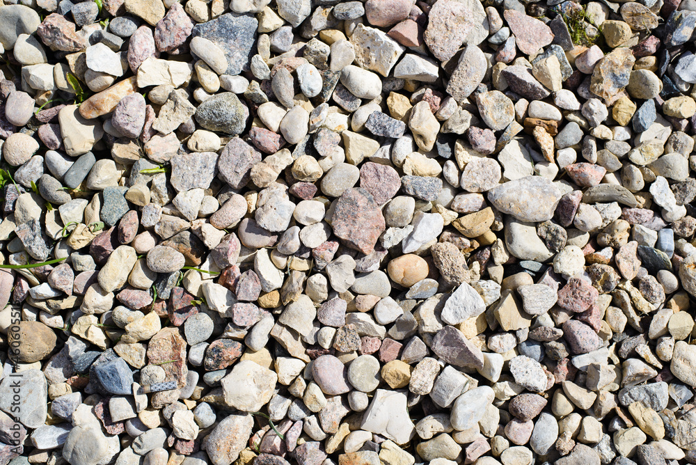 Top view of cobblestones and stones of different sizes and colors outdoors. Textured stone background Top view of cobblestones and stones of different sizes and colors outdoors. Textured stone background