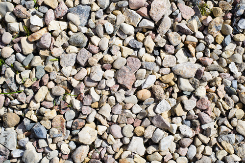 Top view of cobblestones and stones of different sizes and colors outdoors. Textured stone background