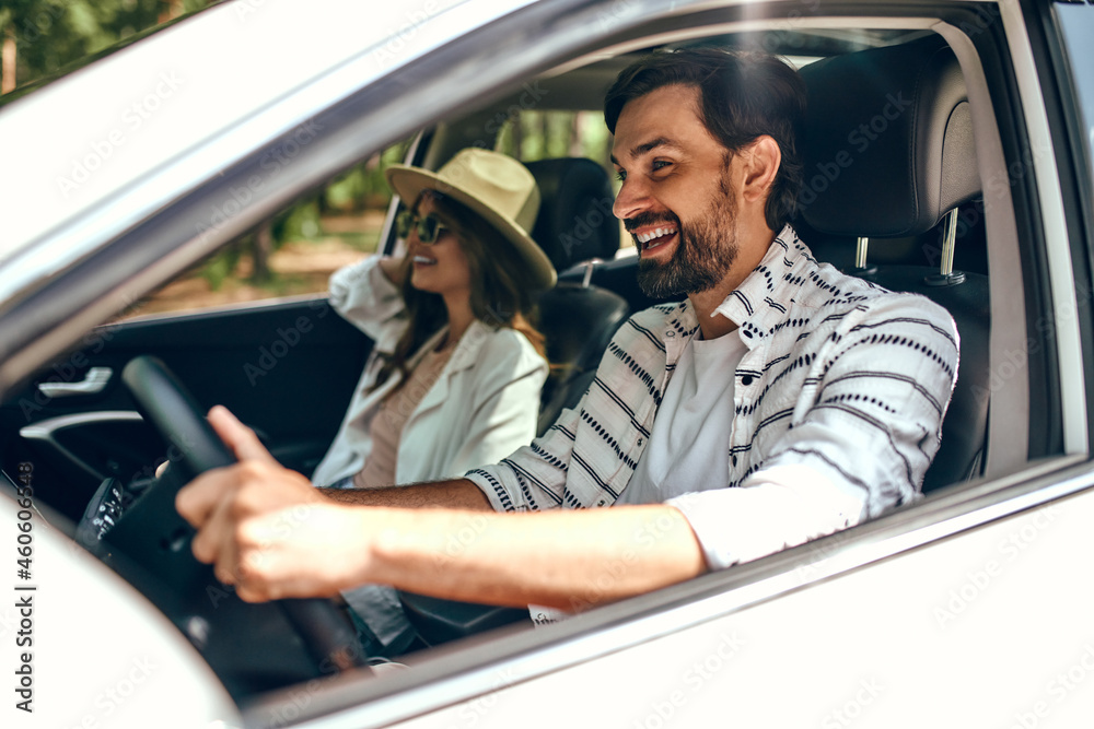 Young couple in a new car. A man driving a car with his girlfriend and