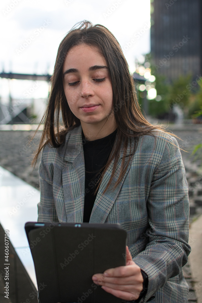 Fototapeta premium mujer trabajando pensativa mirando una tablet