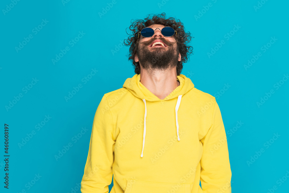 curly hair guy with retro glasses smiling and looking up