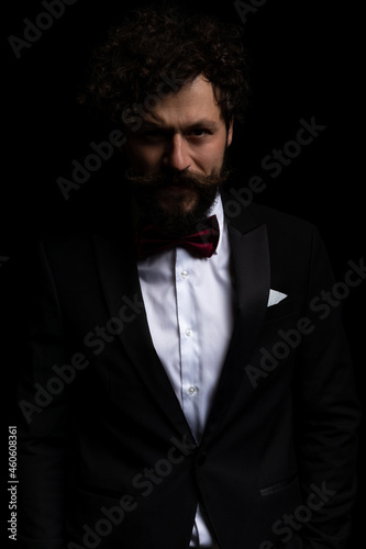 handsome businessman wearing a black tuxedo and purple bowtie