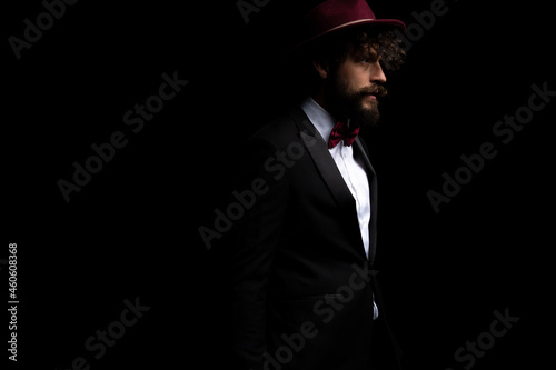 attractive businessman looking away and wearing a burgundy hat