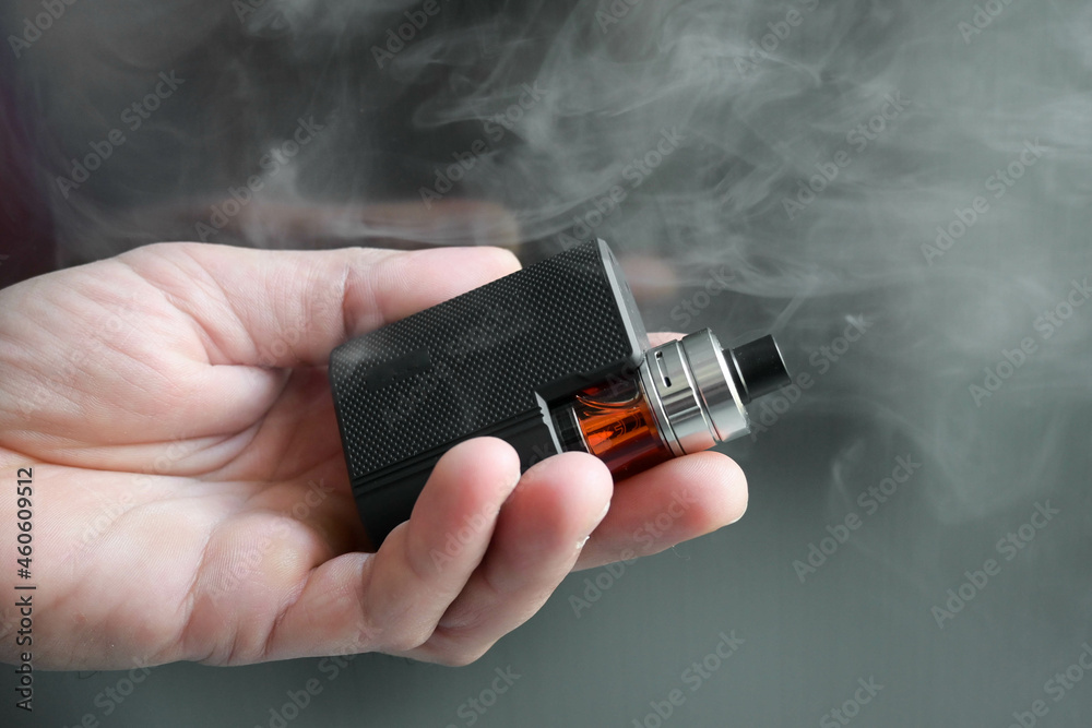 main tenant une cigarette électronique avec de la fumée main tenant une cigarette électronique avec de la fumée