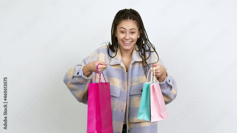 Teenager girl with braids holding shopping bags isolated on background