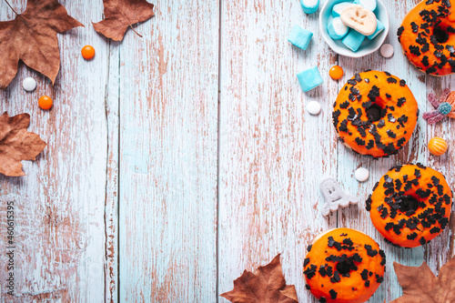 Decorated Halloween pumpkin doughnuts and spooky marshmallows. Halloween border, copy space