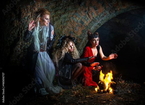 Witches conjure by the fire on Halloween night. Ghost girls.
