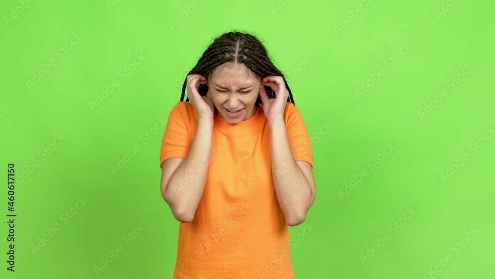 Teenager girl with braids covering both ears with hands. Frustrated expression over isolated background Teenager girl with braids covering both ears with hands. Frustrated expression over isolated background