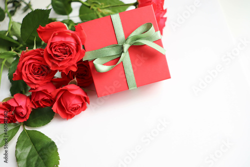 greeting card design. beautiful bouquet of red roses and a gift box on a white background. congratulation. invitation 