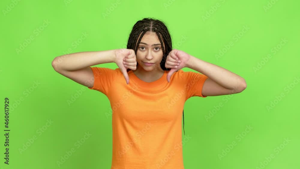 Teenager girl with braids doing bad signal over isolated background. Green screen chroma key Teenager girl with braids doing bad signal over isolated background. Green screen chroma key