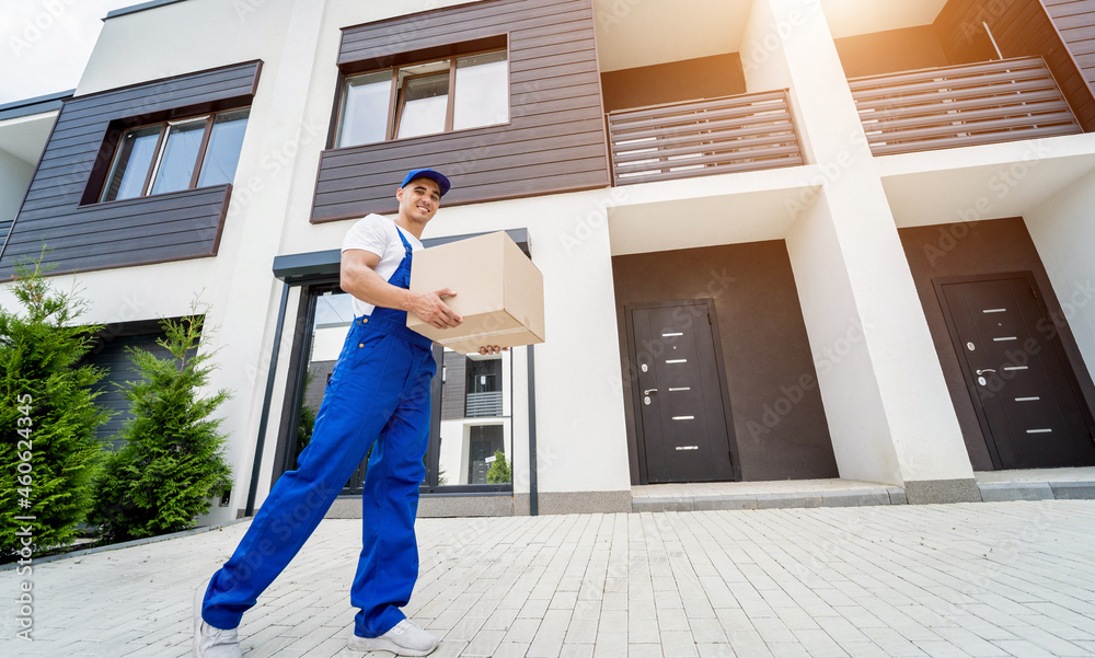 Young delivery man hold a cardboard box in his hands Young delivery man hold a cardboard box in his hands