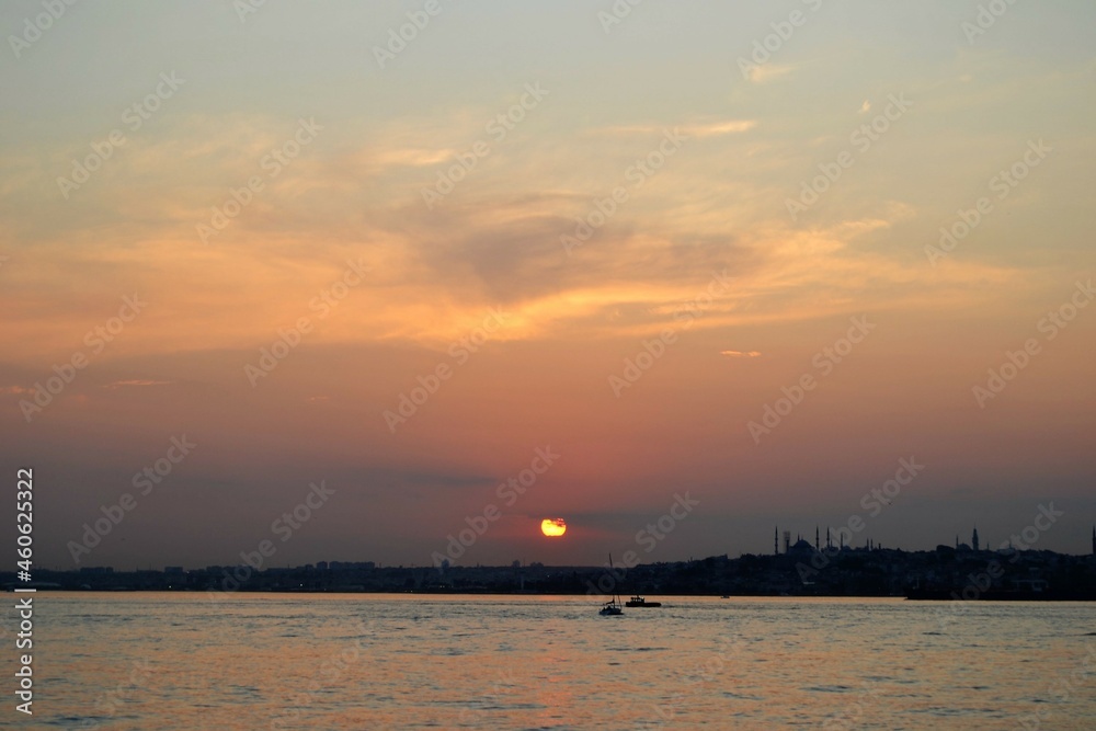 Sunset sky with colorful clouds and sun over sea and horizon. Bosphorus strait, Istanbul during sunset. Sunset sky with colorful clouds and sun over sea and horizon. Bosphorus strait, Istanbul during sunset.