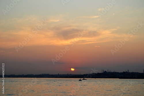 Sunset sky with colorful clouds and sun over sea and  horizon. Bosphorus strait, Istanbul during sunset.