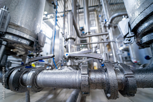 Modern interior of a beverage plant with barrels and pipes