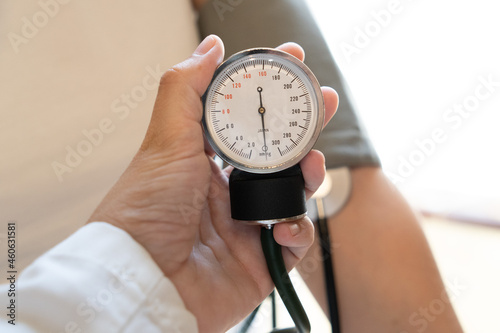 Doctor measuring blood pressure of a young woman 