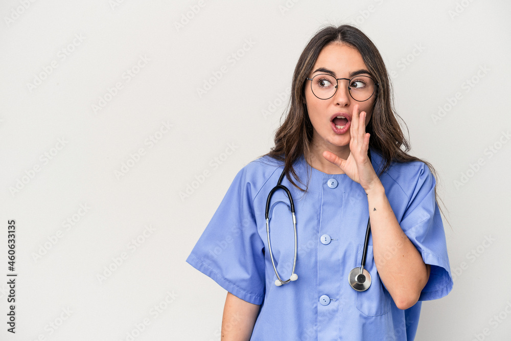 Young caucasian nurse woman isolated on white background is saying a secret hot braking news and looking aside Young caucasian nurse woman isolated on white background is saying a secret hot braking news and looking aside