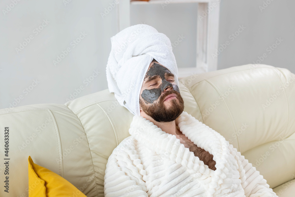 Bearded man has clean fresh skin, wears beauty clay mask on face and enjoys beauty treatments. Spa at home, body and skin care Bearded man has clean fresh skin, wears beauty clay mask on face and enjoys beauty treatments. Spa at home, body and skin care