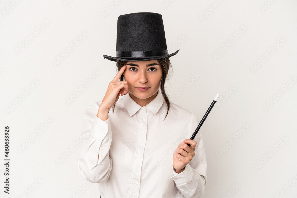 Young magician woman holding a wand isolated on white background pointing temple with finger, thinking, focused on a task. Young magician woman holding a wand isolated on white background pointing temple with finger, thinking, focused on a task.