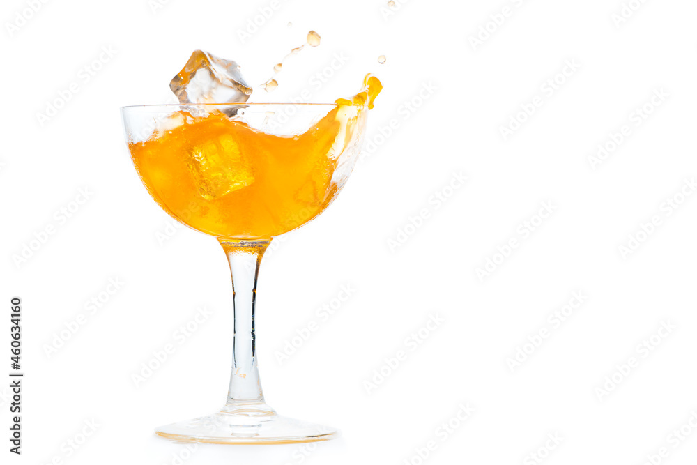 Drop ice cubes in to  orange soda in Margarita glass isolated