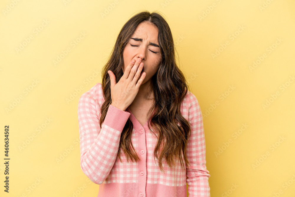 Young caucasian woman isolated on yellow background yawning showing a tired gesture covering mouth with hand. Young caucasian woman isolated on yellow background yawning showing a tired gesture covering mouth with hand.