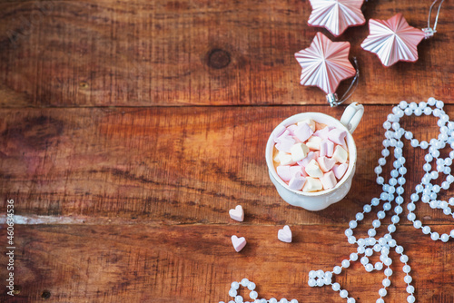 Christmas background. Christmas balls, cup with coffee with marshmallows on a wooden background. Copy space Top view. Christmas or New Year's card. flat lay