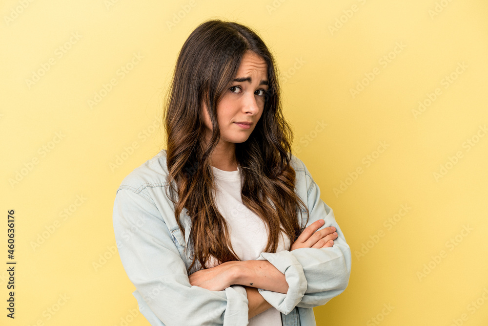 Young caucasian woman isolated on yellow background suspicious, uncertain, examining you.