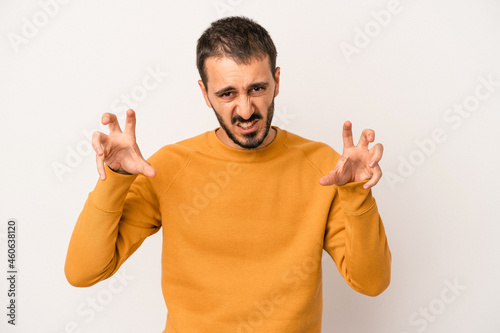 Young caucasian man isolated on white background upset screaming with tense hands.