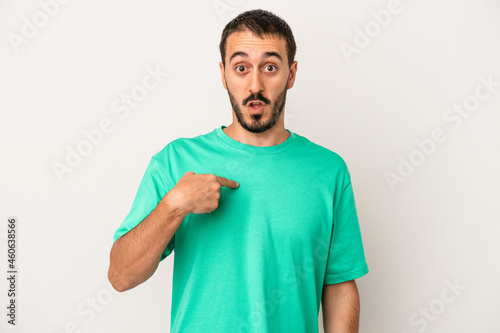 Young caucasian man isolated on white background surprised pointing with finger, smiling broadly.