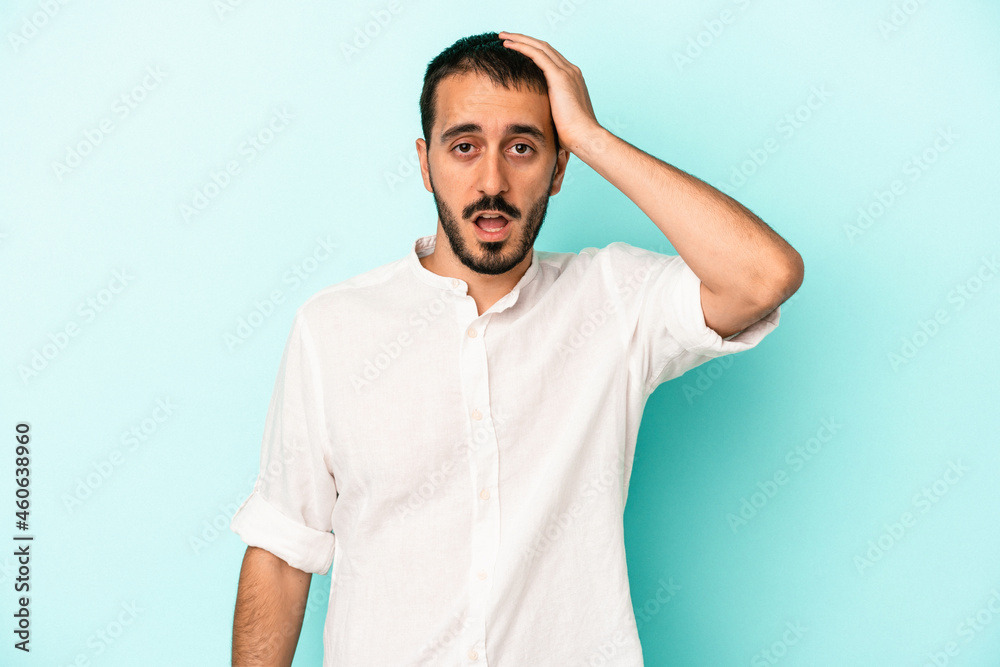 Young caucasian man isolated on blue background being shocked, she has remembered important meeting. Young caucasian man isolated on blue background being shocked, she has remembered important meeting.